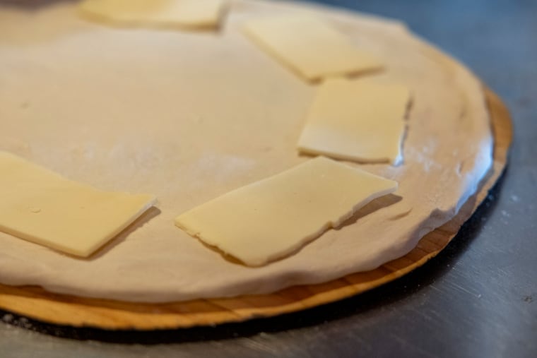 Cooper Sharp cheese is added to the pizza dough for the South Philly Pizzaz pizza at .Cafe Carmela's in Philadelphia, Pa., on Wednesday., April. 1, 2026.