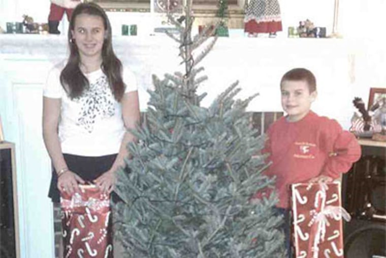 Marissa Cupaiuolo and her brother, Anthony, with gifts donated after fire destroyed their East Goshen Township home. (Family photo provided by Angela Cupaiuolo)