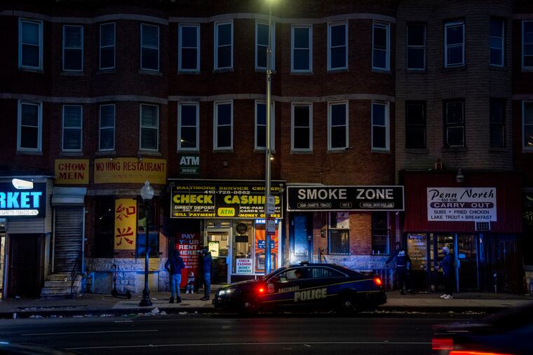 A police officer patrols in West Baltimore on April 17. The Maryland city has considered about $11 million in total reductions that could affect first responders.