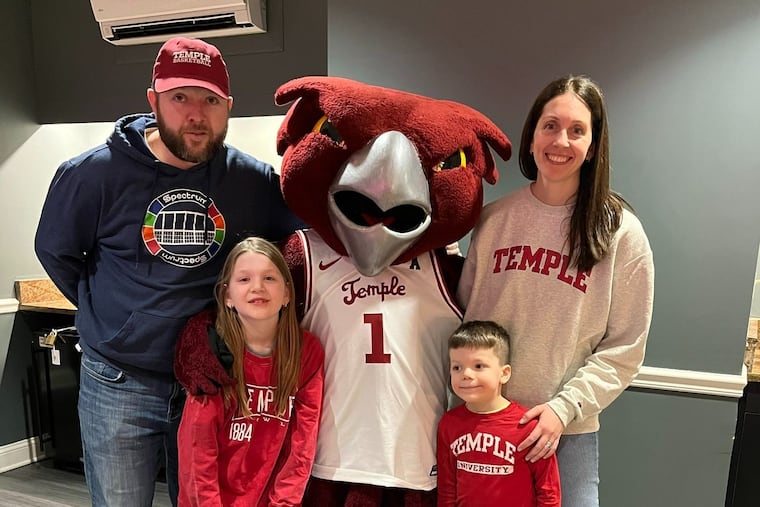 Mac Casey, left, and Liz Moore, right, with their kids Annie, 9, and Michael, 6, at a Skilladelphia event where they took several kids and families to a Temple women's basketball game.