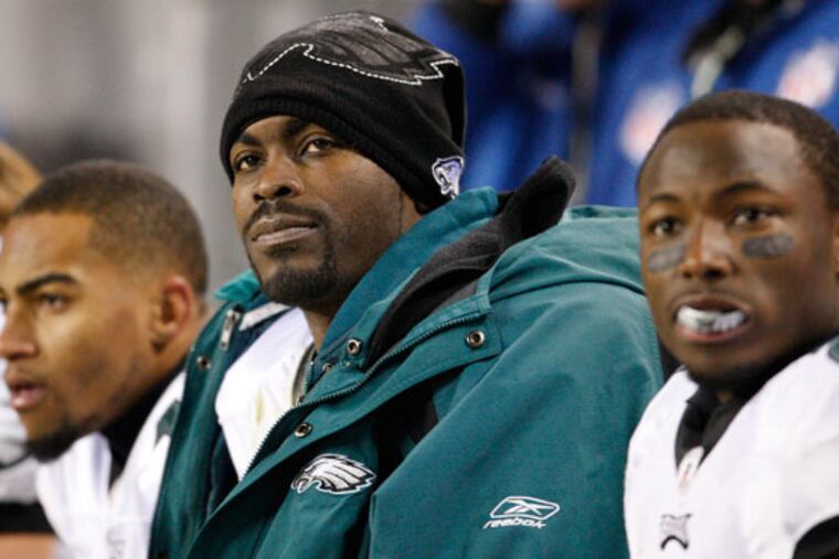 Eagles Michael Vick, flanked by DeSean Jackson, left, and LeSean McCoy, watches a game.