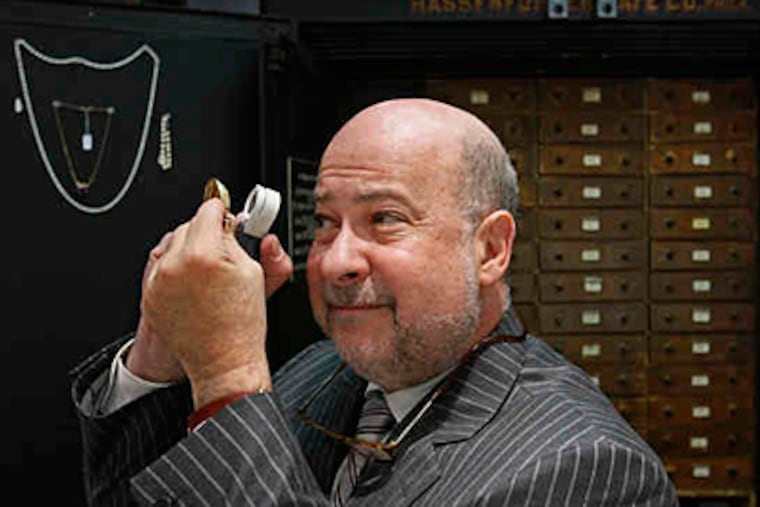 Tod Gordon examines jewelry at Carver W. Reed & Co. Inc., a high-end pawnshop at 10th and Sansom Streets that deals only in gold and diamonds. (Michael S. Wirtz / Staff)