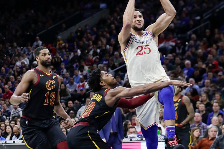 Sixers guard Ben Simmons drives to the basket past Cleveland Cavaliers guard Darius Garland and center Tristan Thompson during the first-quarter,