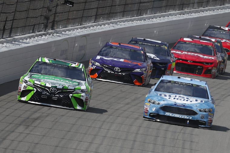 Kyle Busch, left, races Kevin Harvick into Turn 1 during a NASCAR Cup Series auto race at Michigan International Speedway in Brooklyn, Mich., Sunday, Aug. 12, 2018. (AP Photo/Paul Sancya)