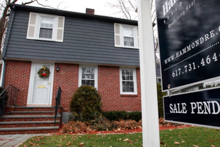 In this Dec. 27, 2011 photo, a sale pending sign hangs in front of a single-family home in Brookline, Mass. The number of Americans who signed contracts to buy homes in November rose to the highest level in a year and a half. (AP Photo/Steven Senne)