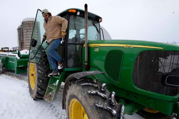 In this Saturday, Jan. 26, 2013 photo, Shawn Georgetti climbs out of his John Deere tractor on his 167-acre family dairy farm in Avella, Pa. With royalties from a Range Resources gas well on his property, Georgetti has been able to buy newer farm equipment that's bigger, faster, and more fuel-efficient. (AP Photo/Gene J. Puskar)