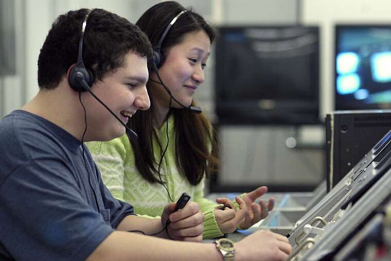 In this 2003 file photo, John Schneider (left) and Nicole Zhang (both names cq) monitor astronauts vitals and shuttle systems in the Space Research Center Club at Northeast High in Philadelphia. (Eric Mencher/File)