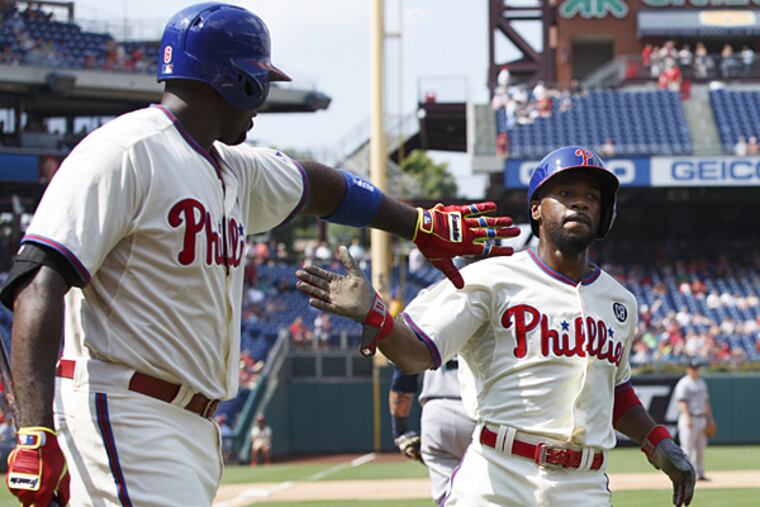 Jimmy Rollins, right, celebrates his run with Ryan Howard, left, on a single by Chase Utley during the fifth inning against the Seattle Mariners on Wednesday, Aug. 20, 2014, in Philadelphia. (Chris Szagola/AP)