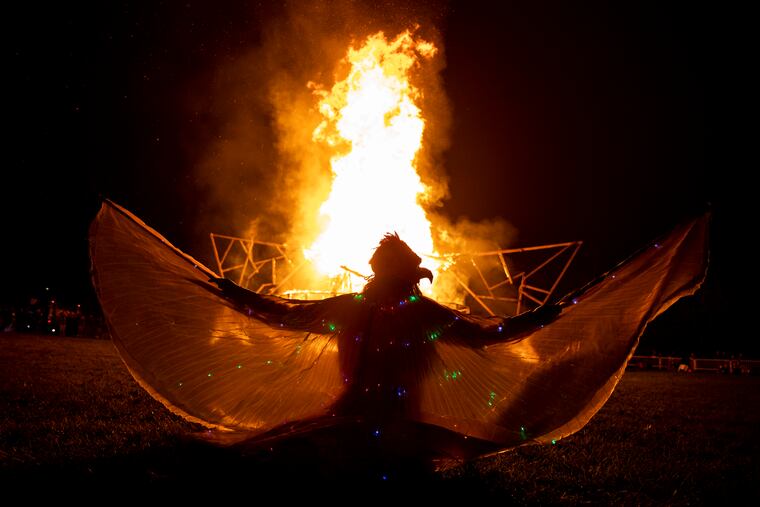 Firebird dancer Sarah Jones of Lyndon, N.J., spreads her wings as the wooden phoenix goes up in flames at the Phoenixville Firebird Festival.