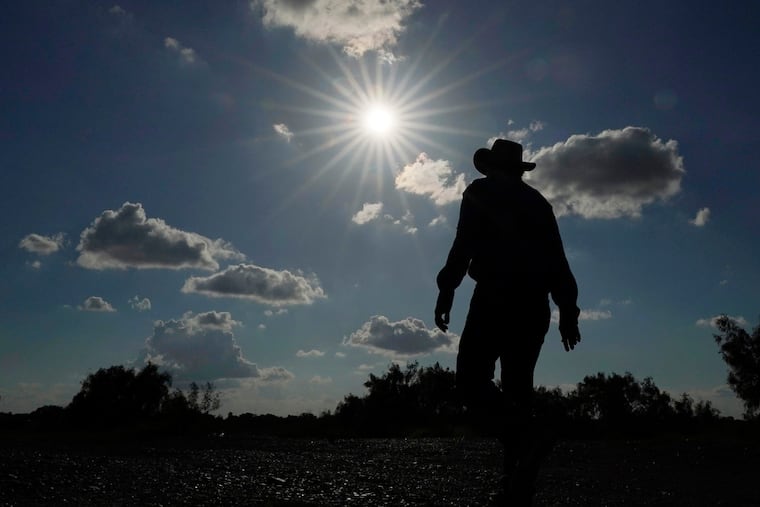 Kayak and canoe outfitter Jessie Fuentes walks along the Rio Grande under a warm sun on Thursday. As the heat breaks records, weakening and sickening people, it’s worth remembering that dire heat waves have inspired effective efforts to prevent heat illness.