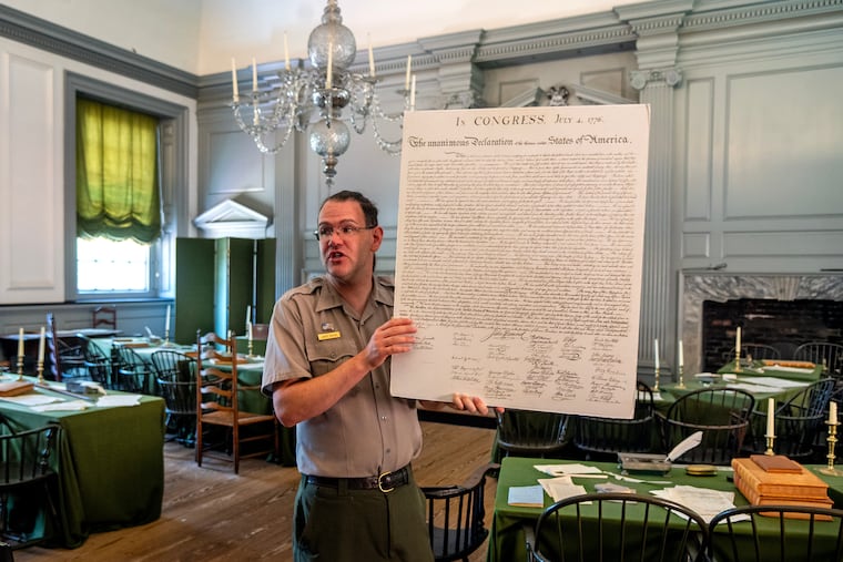 National Park Service ranger James Benson uses an enlarged copy of the Declaration of Independence while talking to visitors in the Assembly Room - where both the Declaration and the U.S. Constitution were signed - on the first floor of Independence Hall.
