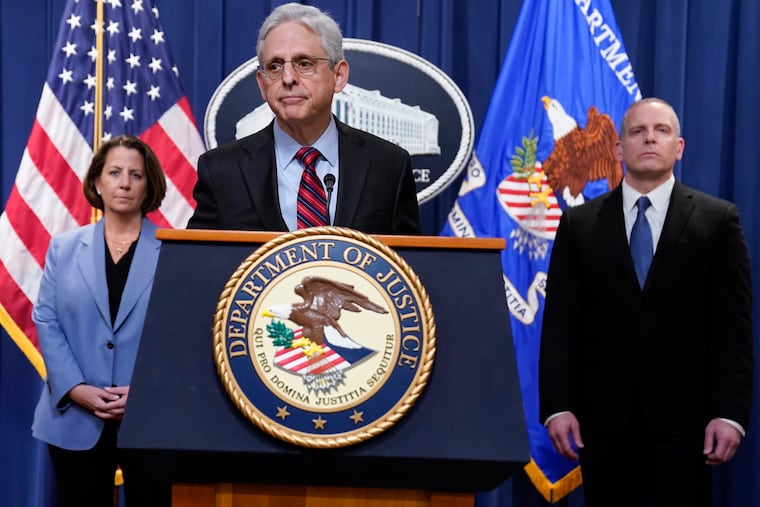 Attorney General Merrick Garland speaks at the Department of Justice, along with FBI Deputy Director Paul Abbate, right, and Deputy Attorney General Lisa Monaco, left.