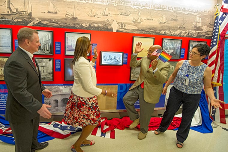 From left: Mark E. Gale, CEO of Philadelphia International Airport; Desiree Peterkin Bell, city representative and executive director of Wawa Welcome America; Mayor Michael Nutter; and Leah Douglas, airport director of exhibitions, celebrate after the unveiling of a new photo exhibit at the airport on July 2, 2015. (CLEM MURRAY/Staff Photographer)