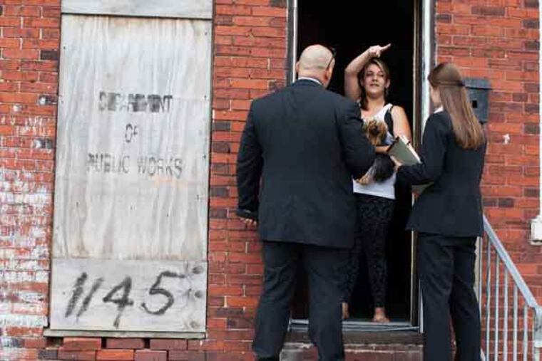 Law enforcement members speak with Sabrina Caban, 18, during a canvas of the neighborhood. Law enforcement officials announced a $21,000 reward in the case of Deogenes Miguel Almonte, who was murdered in his grocery store on Dec. 5, 2011. ( ANDREW RENNEISEN / Staff Photographer )