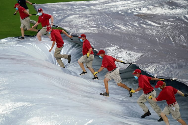 The Cincinnati Reds' grounds crew pulling the tarp after a rain delay last year.