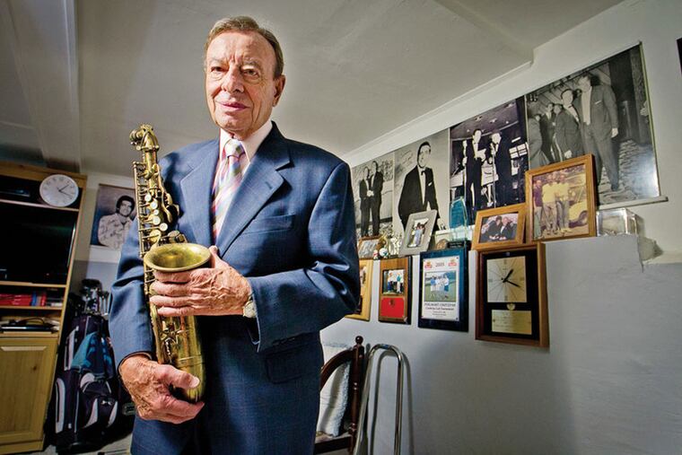 Carmen Dee, whose given name was Carmen DiPipi, seen with his many photos of the old days at Palumbo's, where he was band leader.