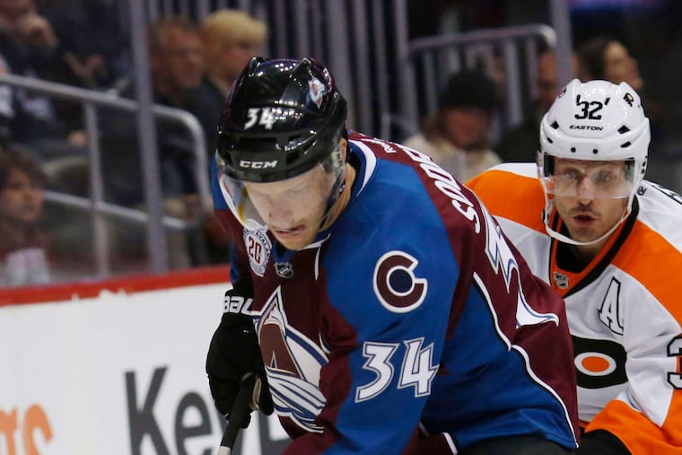 Colorado's Carl Soderberg carries the puck behind the net as Mark Streit pursues.