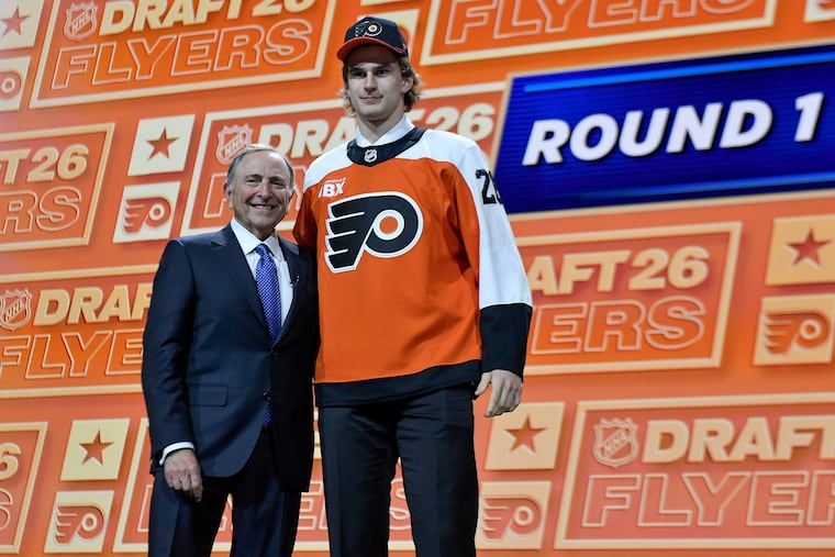 Maksim Sokolovskii, right, stands with NHL commissioner Gary Bettman, left, after being drafted by the Flyers with the 27th pick in the draft.