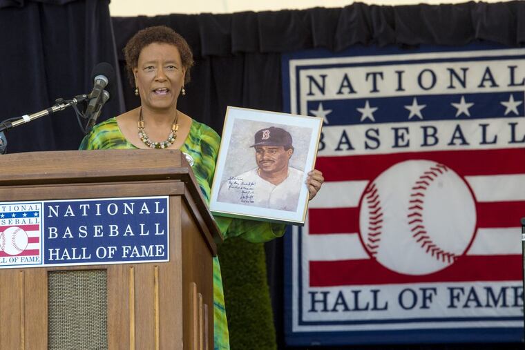 Former Inquirer sports columnist Claire Smith holds up a painting of former player Don Baylor — painted by her father — as she gives her acceptance speech after receiving the J.G.Taylor Spink Award from the Baseball Hall of Fame.