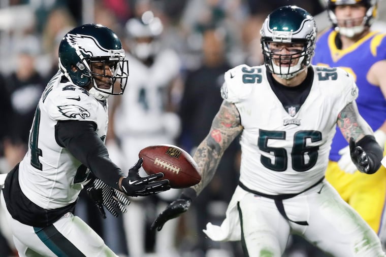 Eagles free safety Corey Graham (left) intercepts the ball as Chris Long looks on.