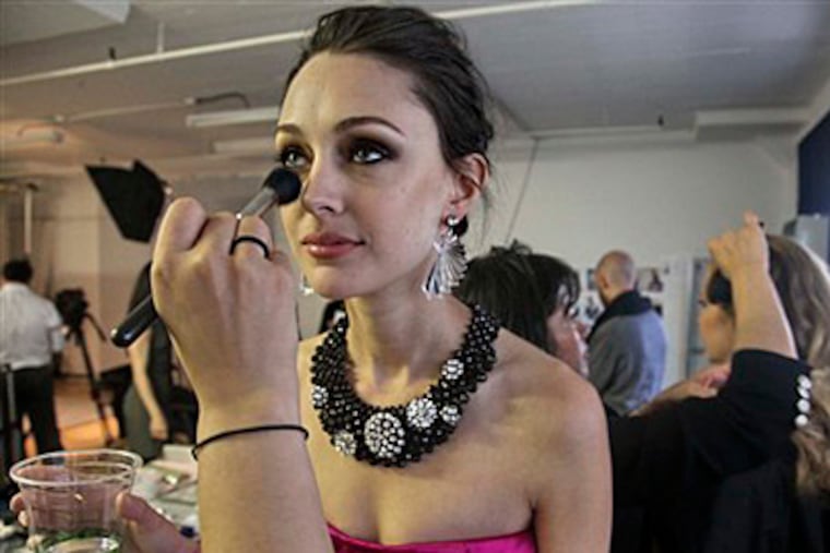 Model Laura McLafferty has make-up applied before a photo shoot at the Gilt Groupe studios in the Brooklyn borough of New York. Gilt Groupe is a sample sale website that converts often avant garde runway looks into reality _ reality that is bought and worn by regular folks. (AP Photo/Bebeto Matthews)