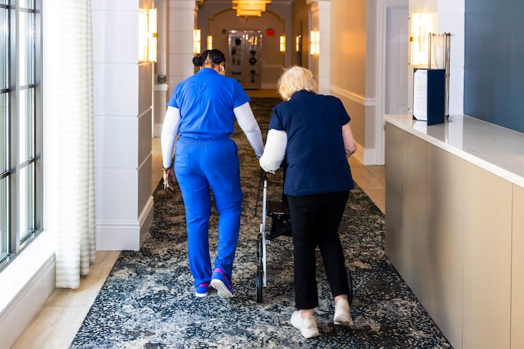A staff member assists a resident of the Sinai Residences in Boca Raton, Florida, in 2025.