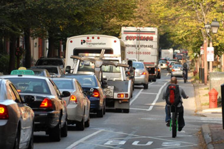 Formerly two lanes for traffic, the Spruce Street bike lane has reduced the street to just one vehicle lane. ( Tom Gralish / Staff Photographer )