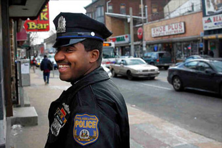 Police Officer Tyshaan Williams walks along Germantown Avenue. Four years ago, when he saw a mother and her infant struggling through the trash on the street, he had to do something. (Laurence Kesterson / Staff Photographer)