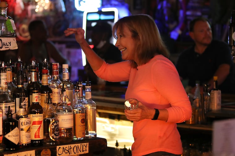 Sharon Suleta waves before pouring a drink while bartending at Dirty Franks. Suleta announced a bucket list that serves as a love letter to Philadelphia and bartending at Dirty Franks is on her list.