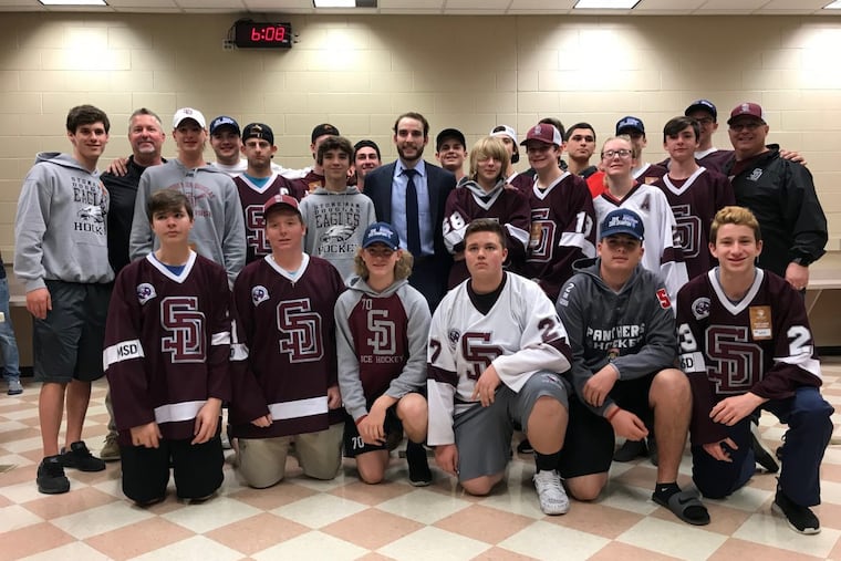 Shayne Gostisbehere with members of Marjory Stoneman Douglas High hockey team
