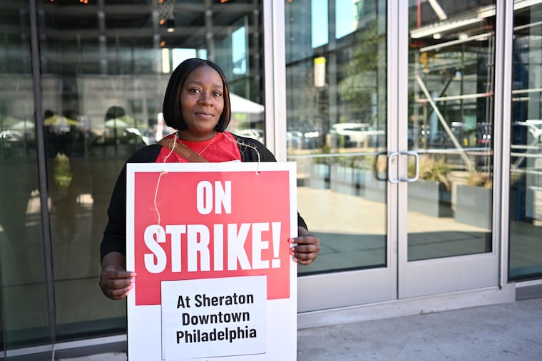 Housekeeping worker Katrina Quarles holds a placard outside the Sheraton hotel in Center City. Quarles and about 150 of her coworkers went on strike Sunday, Oct. 5, 2025.