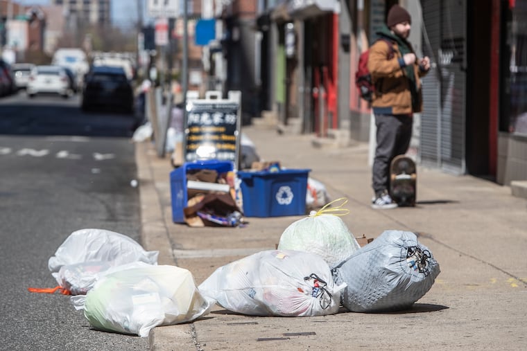 Bags of garbage lay strewn across the sidewalk on North 9th Street in the Chinatown area of Philadelphia on April 2. The city is continuing to pick up trash and recycling but it is doing so on an inconsistent schedule due to coronavirus-related challenges.
