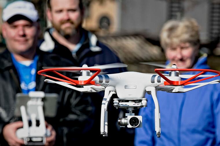 Instructor Brian Ozga shows his students how to fly a DJI Phantom 3 quadcopter, in an empty lot in North Wales.