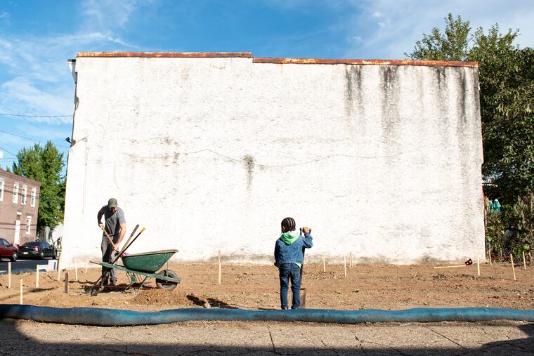 Partners in park building are Teddy Pickering, 38, a senior studying landscape architecture at Jefferson University (left) and Christopher Parnell Jr., 6.