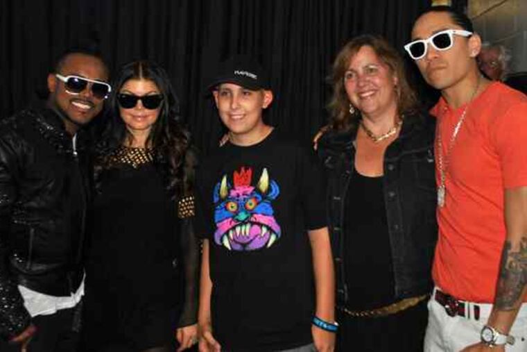 Hunter Brooks (center) and his mother, Mindy Brooks, with Black Eyed Peas (from left) apl.de.ap, Fergie, and Taboo. TD Bank officials got backstage access for Hunter, who has brain cancer, so he could meet the band.