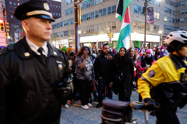 Pro-Palestinian supporters watch the Philadelphia Police during a cease-fire rally near Rittenhouse Square in Center City on Saturday.