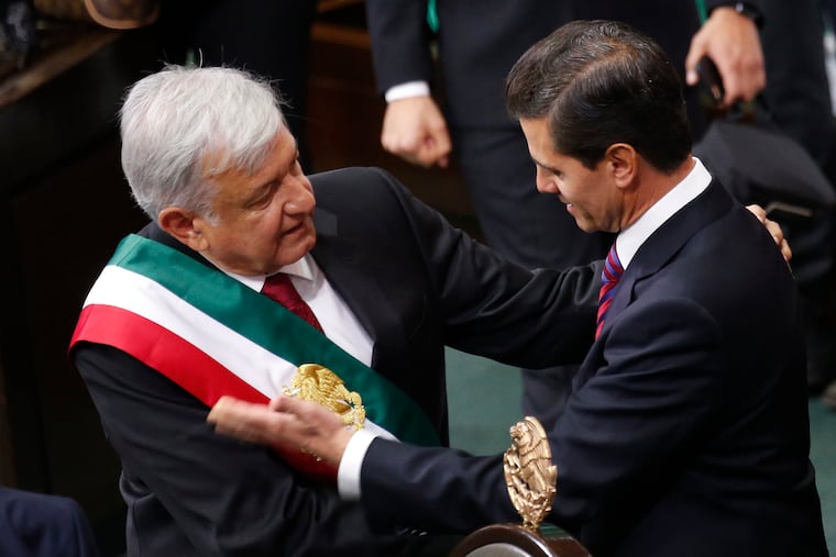 Mexico's new President Andres Manuel Lopez Obrador and outgoing President Enrique Pena Nieto embrace at the end of the swearing-in ceremony in the lower house chambers of the National Congress, in Mexico City, Saturday, Dec. 1, 2018. Lopez Obrador took the oath of office Saturday as Mexico's first leftist president in over 70 years, marking a turning point in one of the world's most radical experiments in opening markets and privatization. (AP Photo/Marco Ugarte)