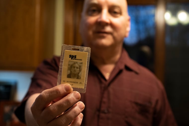 Ed Weinberger, 61, holds his old SPS Technologies ID card at his home in Perkasie on Tuesday. Weinberger left SPS in 2018 after working there for 32 years as a machine operator.