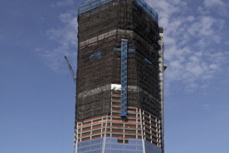In this April 17, 2012, file photo, One World Trade Center, now up to 100 floors, rises above the Manhattan skyline in New York. On Monday, April 30, One World Trade Center _ being built to replace the twin towers destroyed on 9/11 _ gets steel columns to make its unfinished framework a little higher than the Empire State Building's observation deck, to become the tallest building in New York. (AP Photo/Mark Lennihan)