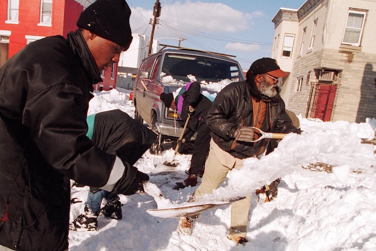 Two men clean snow away from the path of a van stuck in the snow in Strawberry Mansion after Philly's record snowfall in January 1996. Another record was set in New Jersey, but it took awhile to get an official stamp of approval.