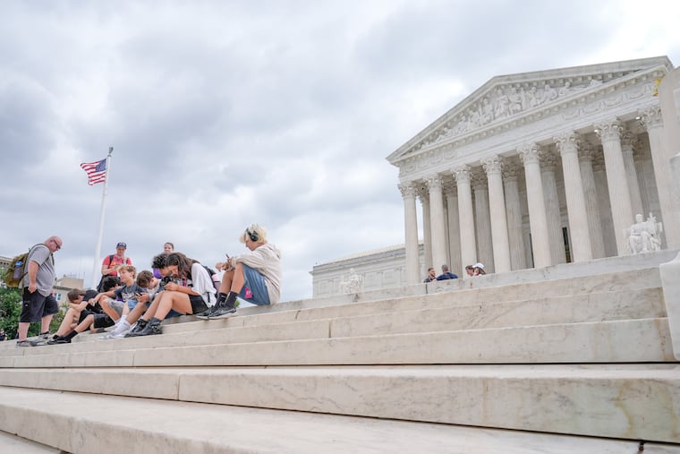 Visitors sit on the steps of the U.S. Supreme Court, Monday, June 8, 2026, in Washington.