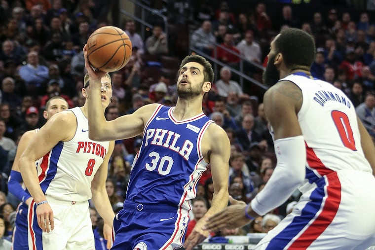Sixers' Furkan Korkmaz drives between Pistons' Henry Ellenson, left and Andre Drummond during the 2nd quarter at the Wells Fargo Center in Philadelphia, Monday, Dec. 10, 2018. (STEVEN M. FALK / Staff Photographer)