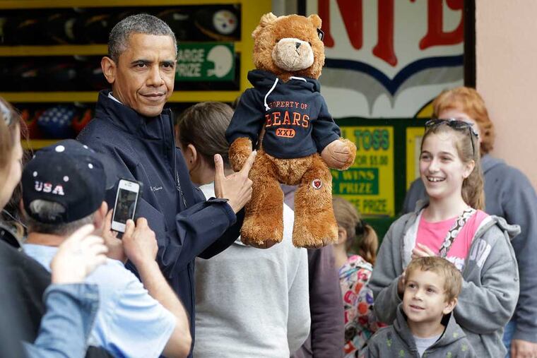 President Barack Obama holds up a stuffed bear that New Jersey Gov. Chris Christie, not shown, had won tossing a football after playing the 'Touchdown Fever' game on the boardwalk during their visit to Point Pleasant, NJ., Tuesday, May 28, 2013. Obama traveled to New Jersey to join Christie to inspect and tour the Jersey Shore's recovery efforts from Hurricane Sandy. (AP Photo/Pablo Martinez Monsivais)
