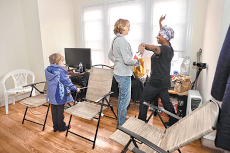Imani Sullivan got a new job and an apartment after our readers helped her out. At Sullivan's housewarming party, Mariana Chilton, a child hunger expert at Drexel University's School of Public Health, is greeted by Sullivan's son, Asem, 4, and his friend Safee Jackson, 4. (Sharon Gekoski-Kimmel / Staff Photographer)