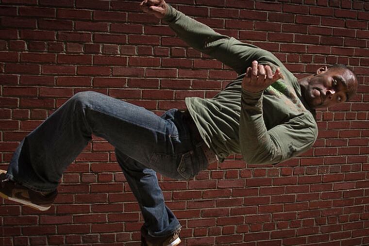 Taleon Goffney shows off a parkour move, "540 Technique," along Filbert St. near 8th Street in Philadelphia on Thursday, May 1, 2014. He was incarcerated for six years with brother Kayontyli Goffney after cutting holes in roof of local businesses to gain entry. ( ALEJANDRO A. ALVAREZ / STAFF PHOTOGRAPHER )