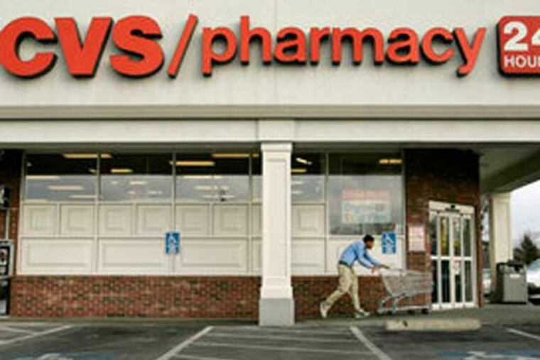 An employee gathers shopping carts at a CVS in East Providence, R.I. (AP file photo)