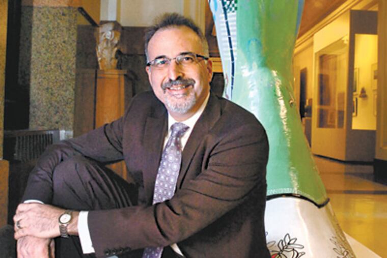 At City Hall Gary Steuer sits with a boot sculpture, installed by Moore College of Art. (Clem Murray / Staff Photographer)