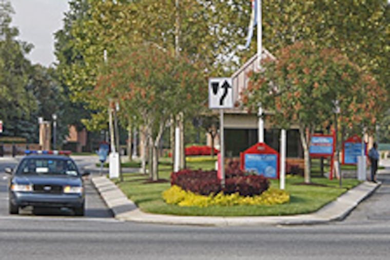 A former college official at Delaware State University, in the background, plead guilty to accepting bribes.