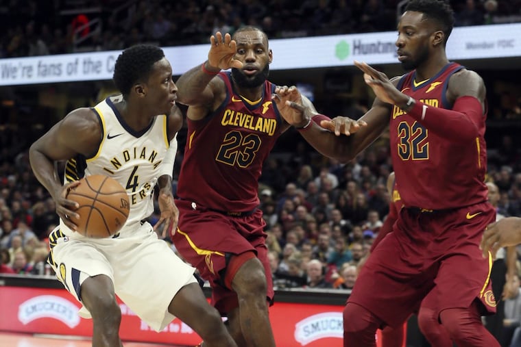 The Indiana Pacers' Victor Oladipo (4) is defended by Cleveland Cavaliers LeBron James (23) and Jeff Green (32) on Wednesday.