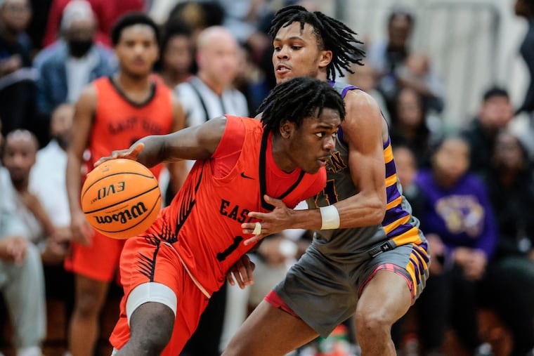 Camden High School's DJ Wagner (right) guards Eastside High's School's Titus Bacon (left with ball) during a game at Cherry Hill East on Feb. 16.